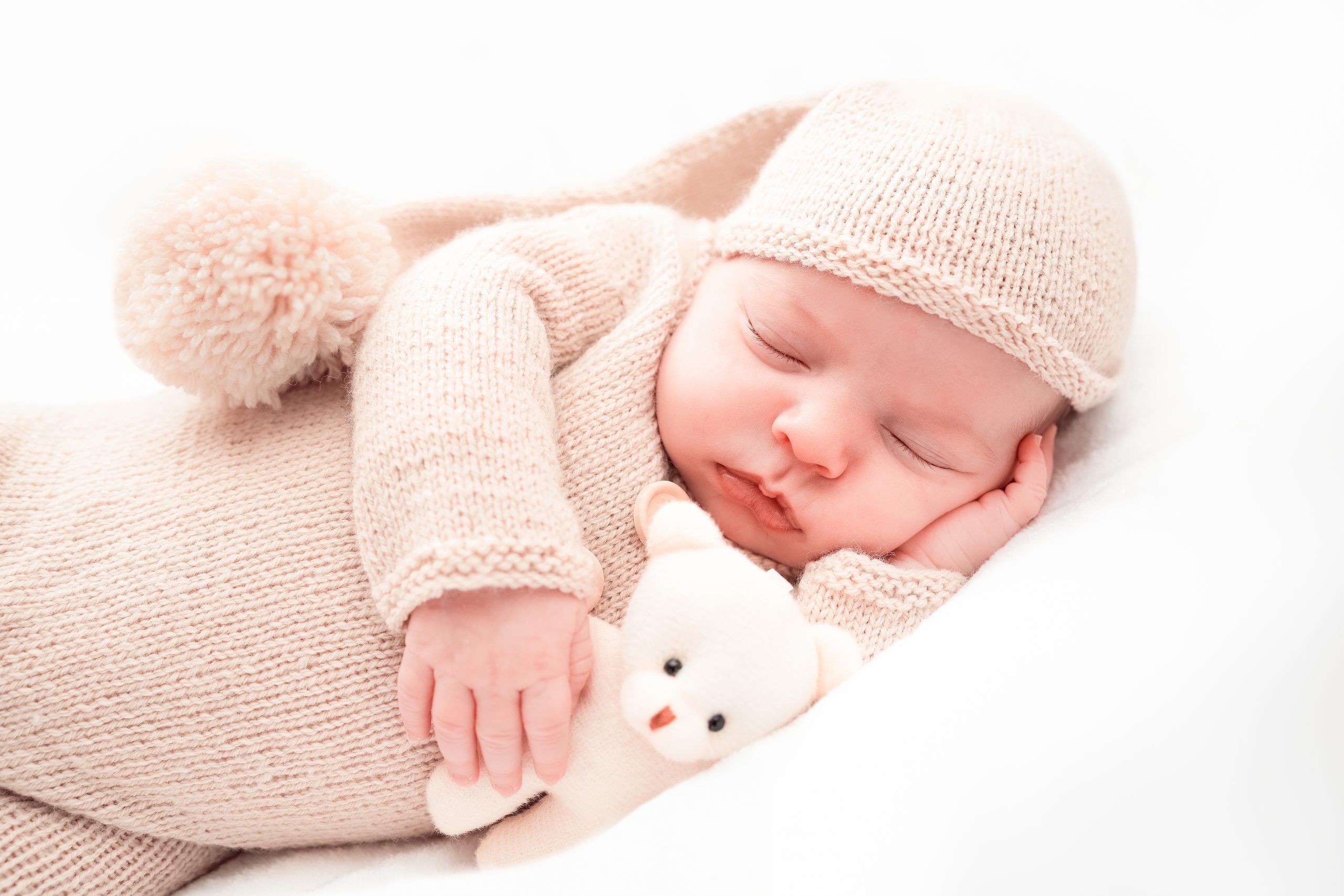 shooting naissance nouveau né endormi pyjama avec doudou dans les bras par photographe le mans en sarthe