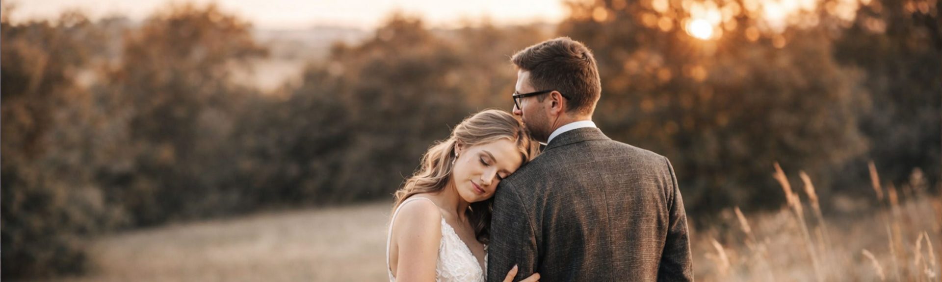 seance photo de couple de maries dans un champ au coucher du soleil